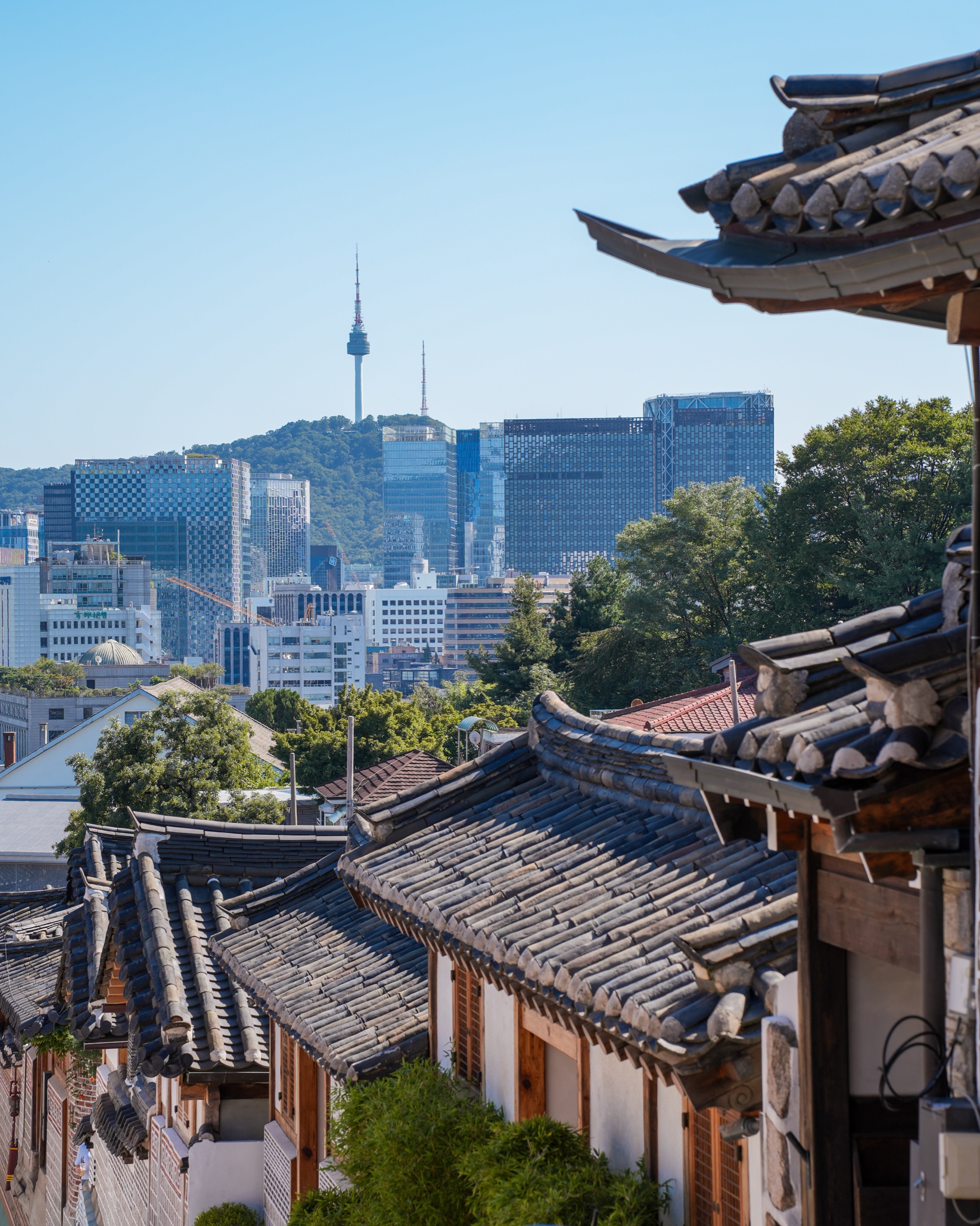 Hanok rooftops in Bukchon with N Seoul Tower and the city skyline in the distance