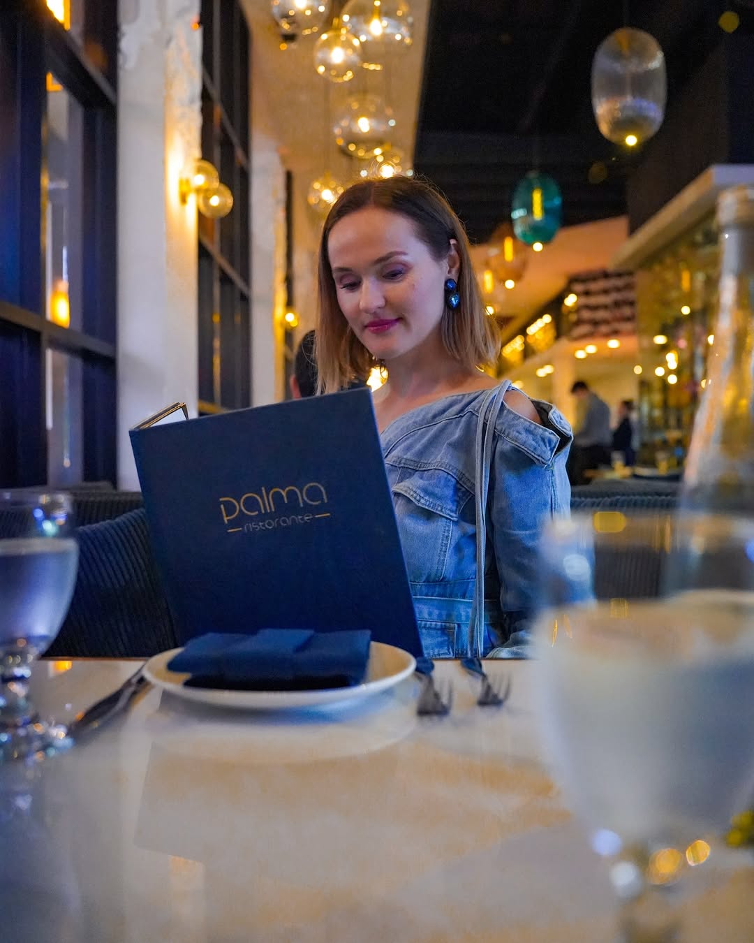 Polina reading the menu at a table at Palma in Burbank
