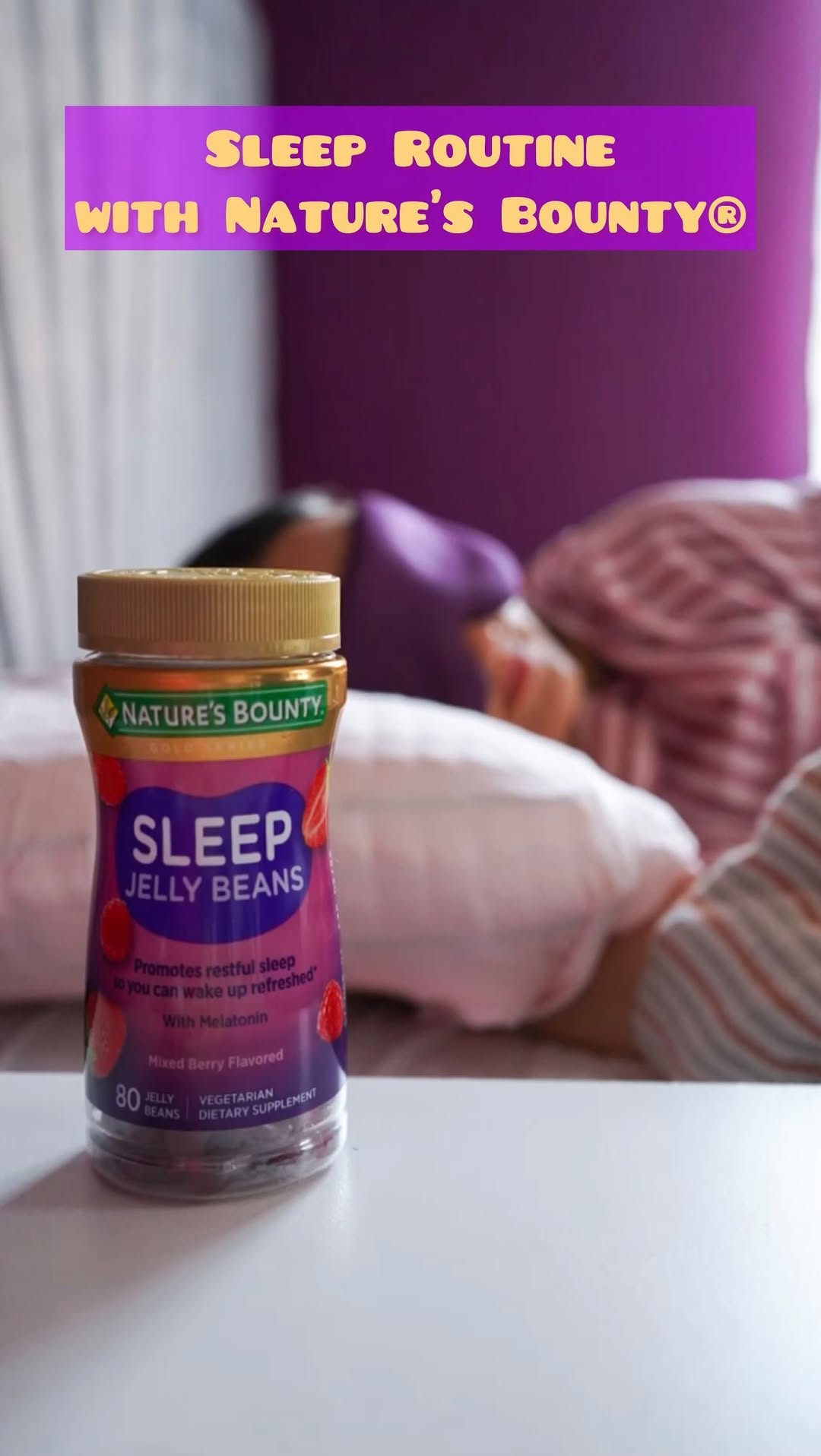 A bottle of Nature's Bounty Sleep Jelly Beans on a table beside a bed